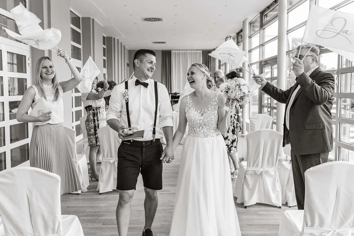 Hochzeitsgesellschaft lachend nach der Trauung